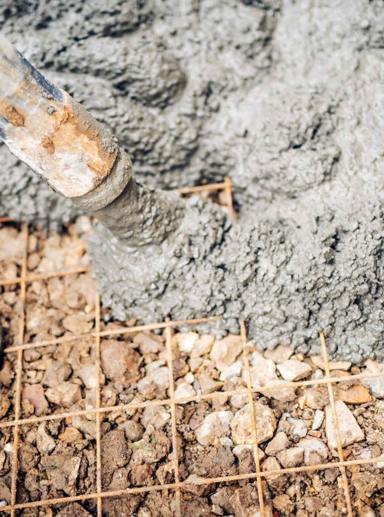 close up of construction workers using cement pump tube